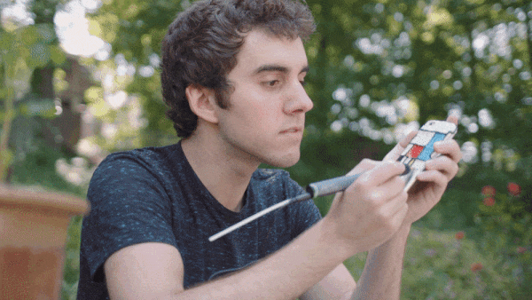 Man holding phone in hand creating 3D pen art